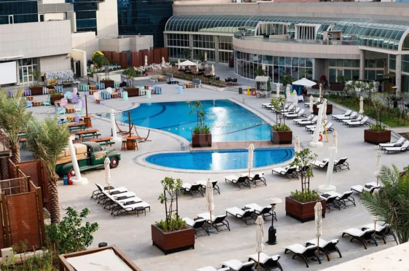Swimming pool at Al Ain Palace Hotel in Abu Dhabi featuring a rectangular and kidney-shaped design with lounge