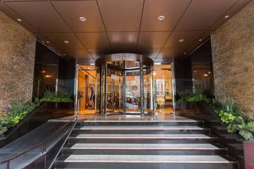 Grand Central Hotel Dubai entrance hall featuring a glass revolving door, black and grey marble steps, and brick