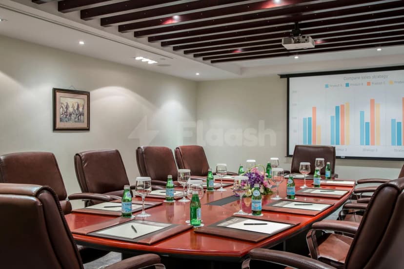 Boardroom at Metropolitan Al Mafraq Hotel in Abu Dhabi with a bar chart presentation on screen