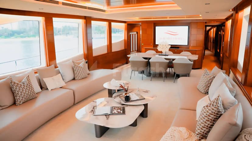 Meeting room on Xclusive 35 Yacht Dubai featuring beige sectional sofas, white marble coffee tables, and large windows