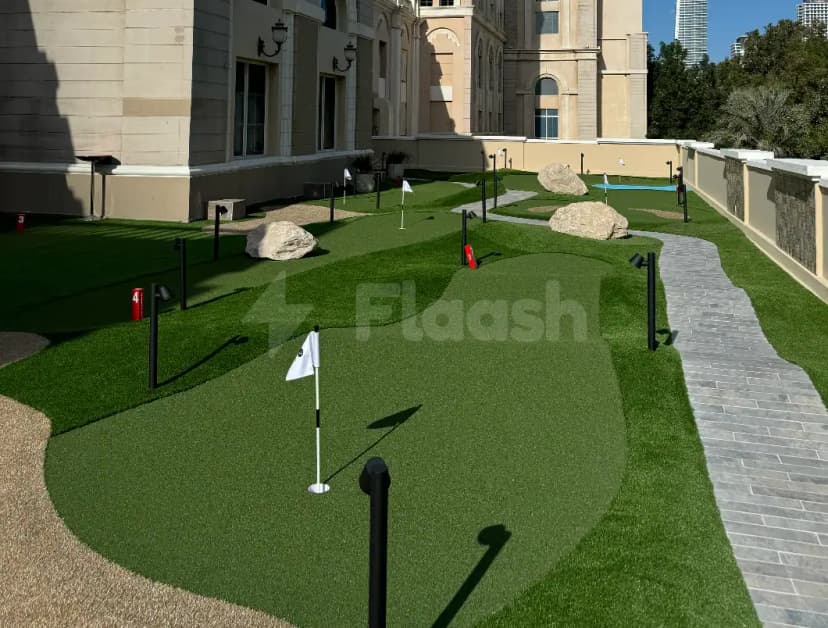 Rooftop terrace at Five Iron Golf Dubai featuring an artificial grass mini golf course with white flags