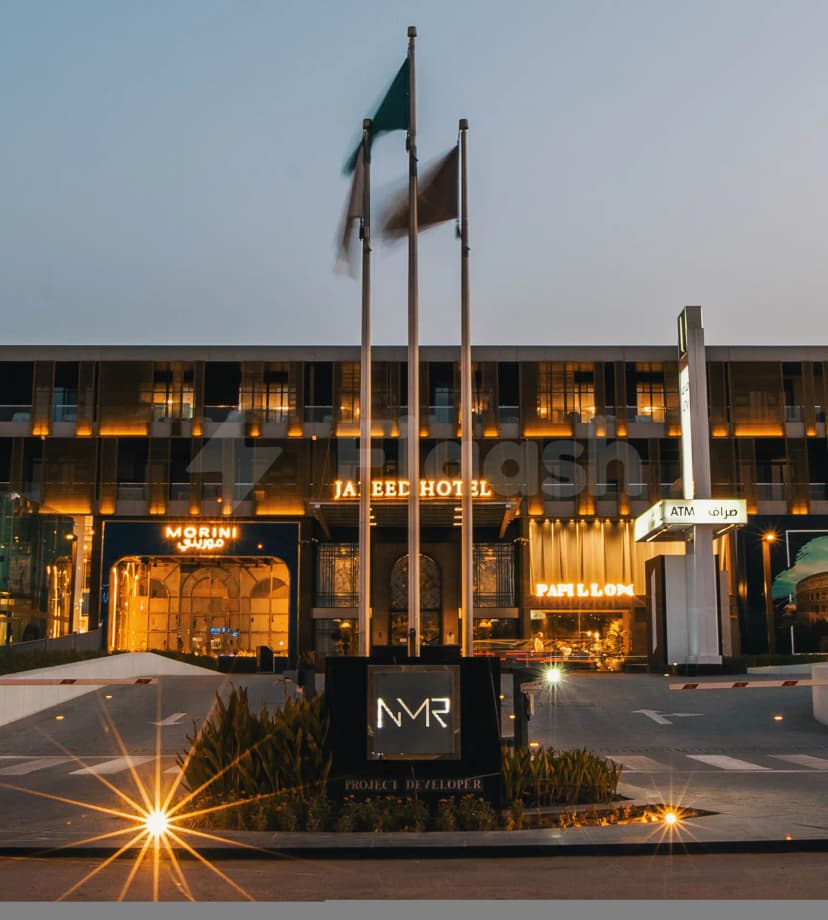 Hotel facade of Jareed Hotel Riyadh at dusk with illuminated signage for Morini and Papillon restaurants and three