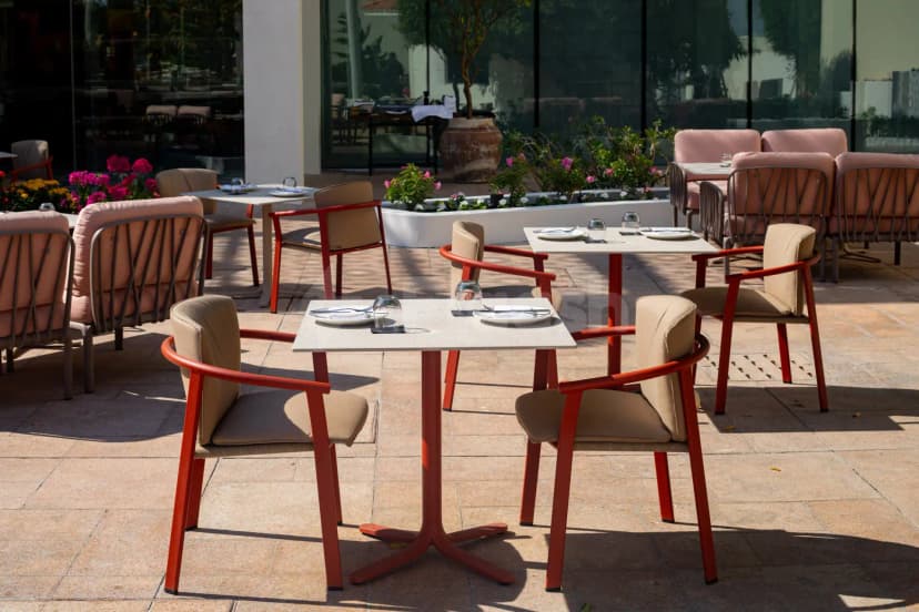 Rooftop terrace at Taparelle Restaurant in Abu Dhabi with square stone tables and potted pink flowers
