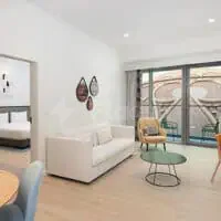 Meeting Room at Rove Expo 2020 Dubai featuring a white sofa, yellow armchair, and large glass sliding doors