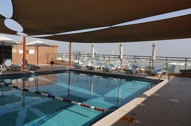 Rooftop terrace at Sheraton Khalidiya Abu Dhabi featuring a rectangular pool with red and white lane dividers under