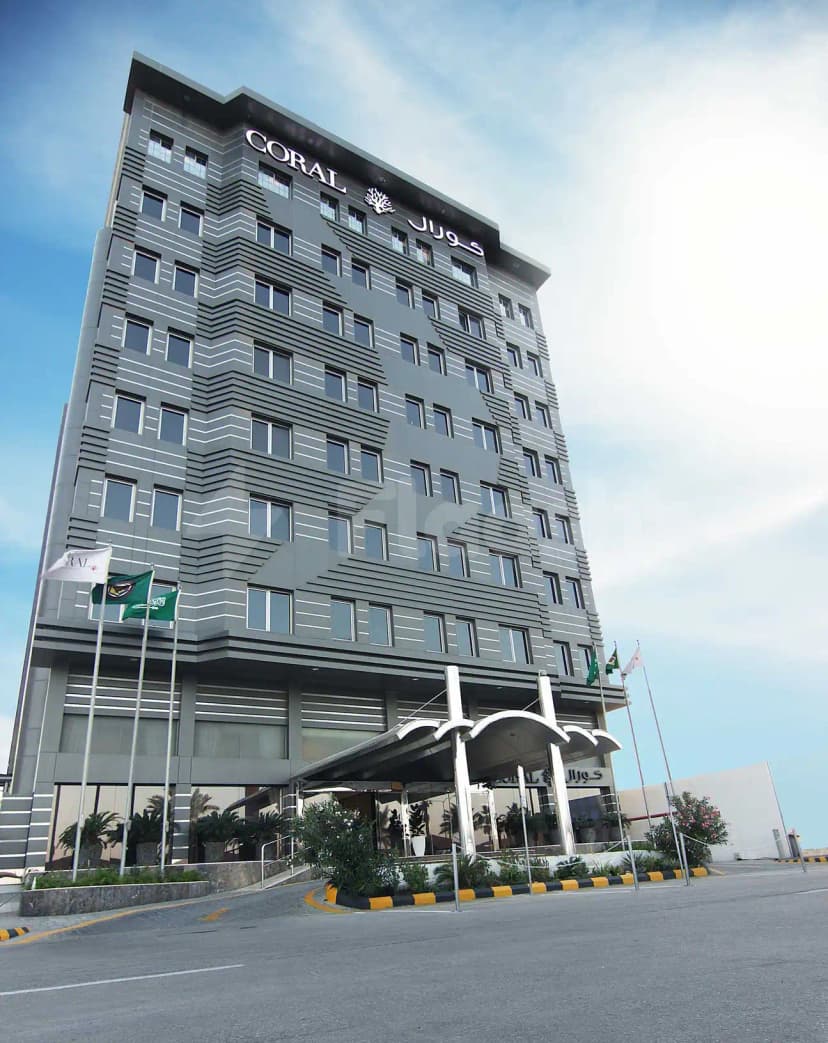 Hotel facade of Coral Jubail in Al Jubail featuring grey striped cladding, entrance canopy with silver supports