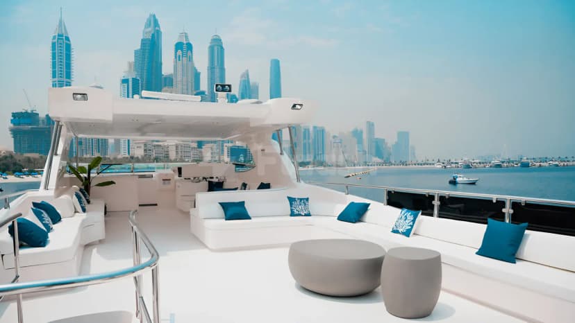 Xclusive 35 Yacht Dubai deck featuring white modular seating and a grey coffee table, with Dubai skyline