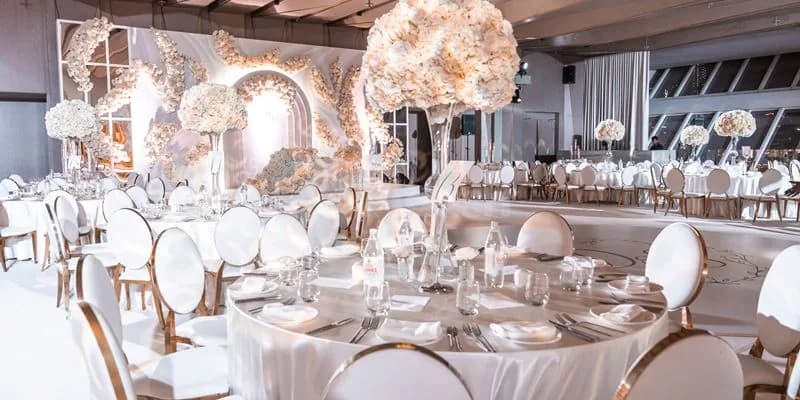 Ballroom at Beach By Five Beach Party Dubai with large white floral centerpieces and arched backdrop