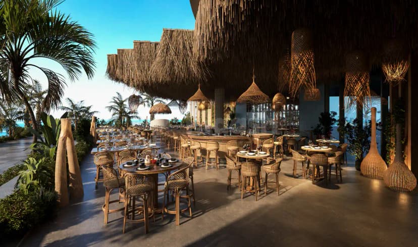 Terrace at Bar du Port Abu Dhabi featuring a layered thatched roof and hanging wicker lamps with ocean
