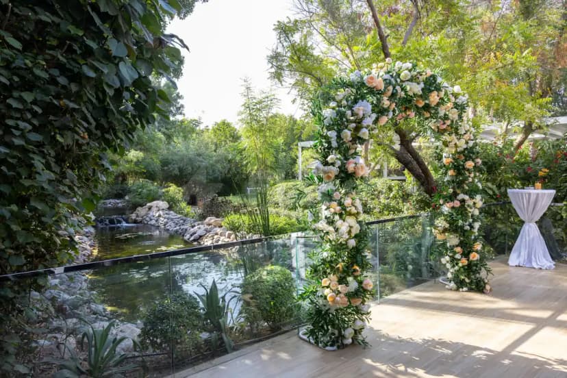Elevated wooden terrace at The Farm Restaurant Al Barari in Dubai with a floral arch and glass railing
