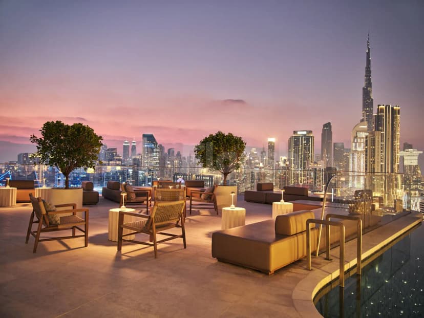 Rooftop terrace at Riviera By Jean Imbert Dubai Business Bay featuring an infinity pool and illuminated city skyline