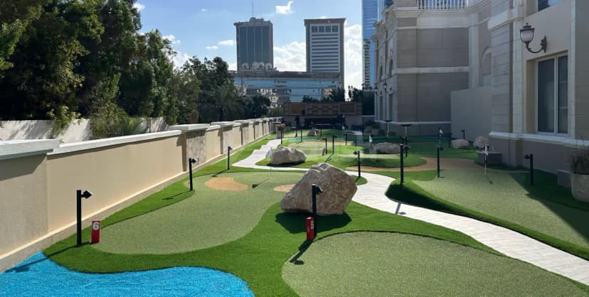 Rooftop terrace at Five Iron Golf Dubai with miniature golf course and blue water feature