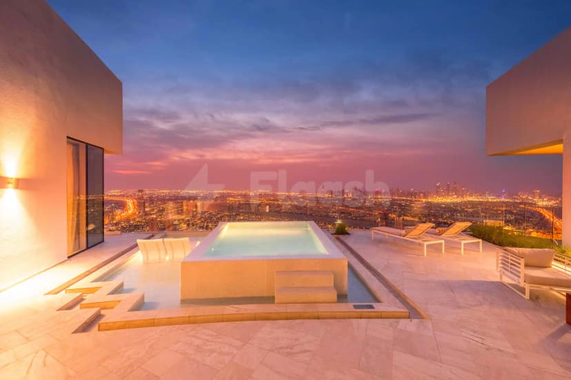 Rooftop terrace at Five Jumeirah Village in Dubai featuring an infinity pool and lounge chairs with a city