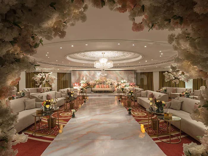 Ballroom at Al Mashreq Boutique Hotel in Riyadh featuring a marble floor aisle, floral archway entrance, and ornate