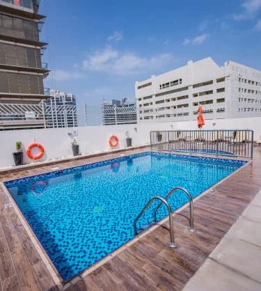 Rectangular swimming pool at Mena Plaza Hotel Albarsha in Dubai with blue mosaic tiles