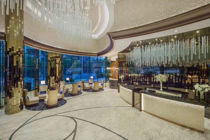 Entrance hall at Blooms Ava Restaurant in Dubai with curved reception desk and white carved paneling
