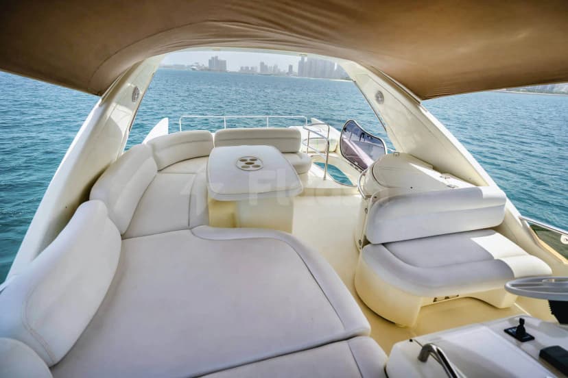 Azimut 62 Lucky Star Yacht Dubai deck with white leather seating, central table, and city skyline view
