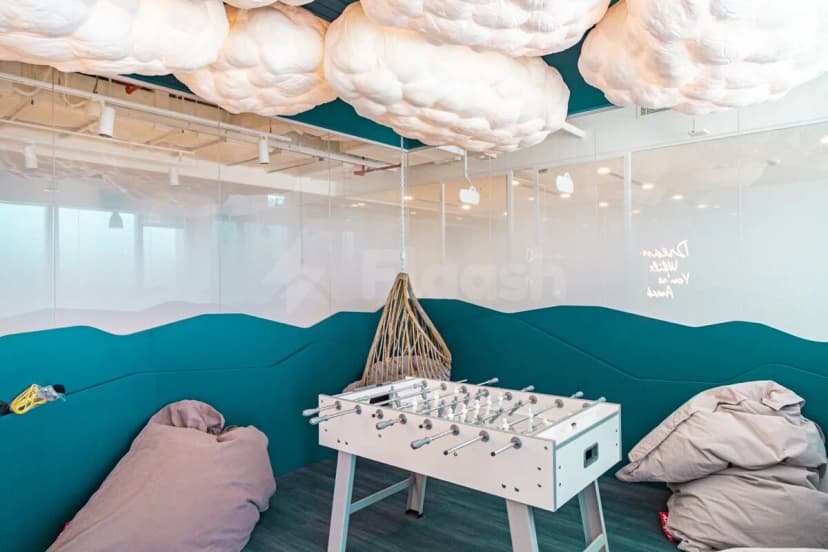 Cloud Spaces ADGM Abu Dhabi leisure area featuring a white foosball table and hanging cloud light fixtures