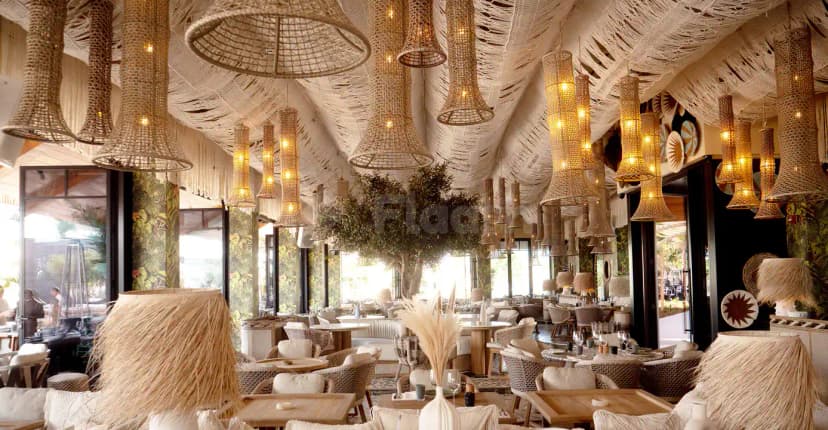 Verde Beach Restaurant Dubai features a spacious indoor dining area with woven pendant lights and a white macrame