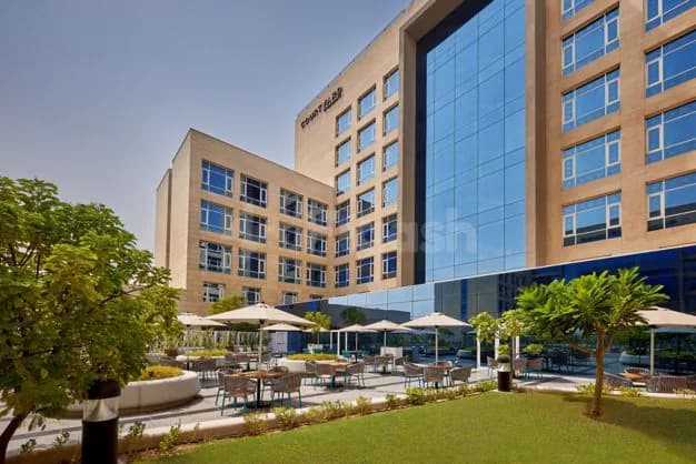 Rooftop terrace at Courtyard Jubail in Al Jubail with white umbrellas and green lawn