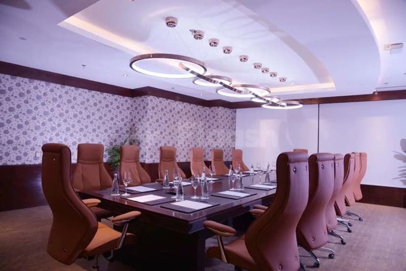 Boardroom at Warwick Al Khobar in Al Khobar featuring a long table, brown leather chairs, floral wallpaper