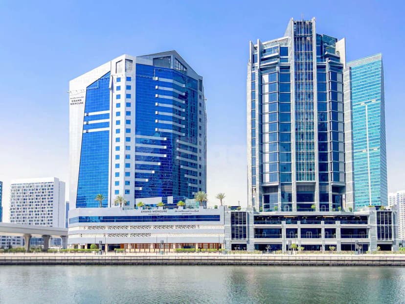 Hotel facade of Gulf Court Hotel Business Bay in Dubai featuring blue reflective glass, white stone cladding