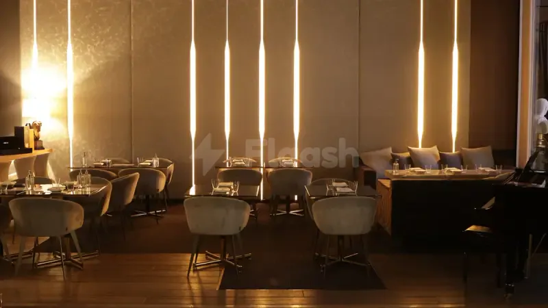 TakaHisa Restaurant Dubai features a modern dining space with vertical wall lighting and a black grand piano