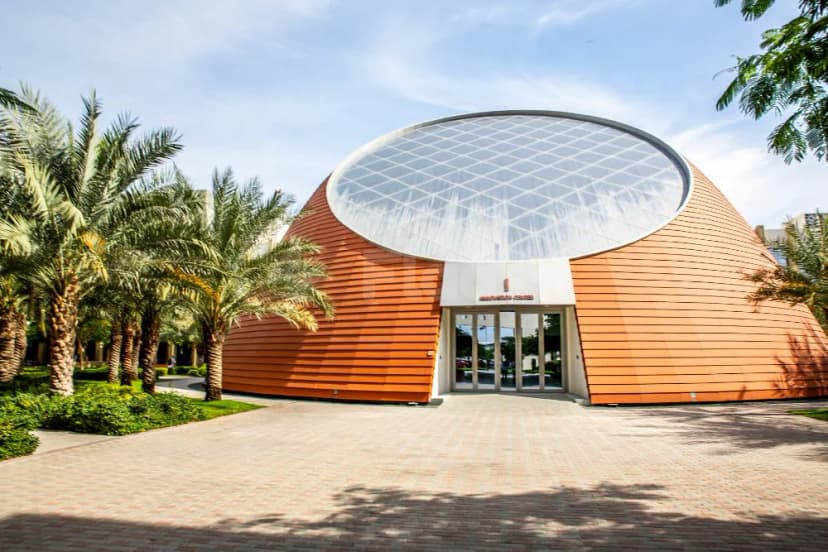 Dubai Silicon Oasis Authority facade in Dubai featuring a large glass dome and orange wooden cladding with palm