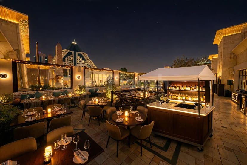 Rooftop terrace at Ashas Restaurant Dubai featuring candlelit tables and a mobile bar cart under night sky