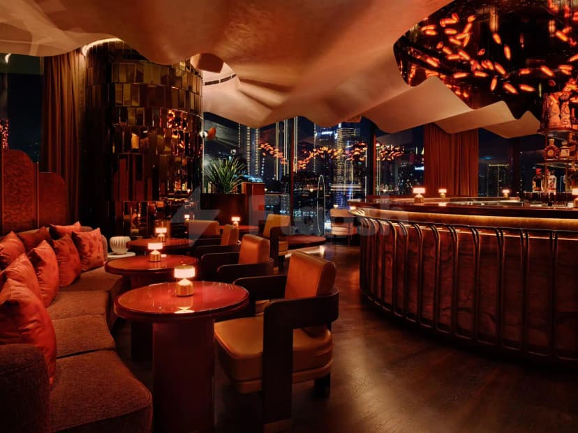 Bar counter at Riviera By Jean Imbert Dubai Business Bay with wooden front, leather chairs, and city night