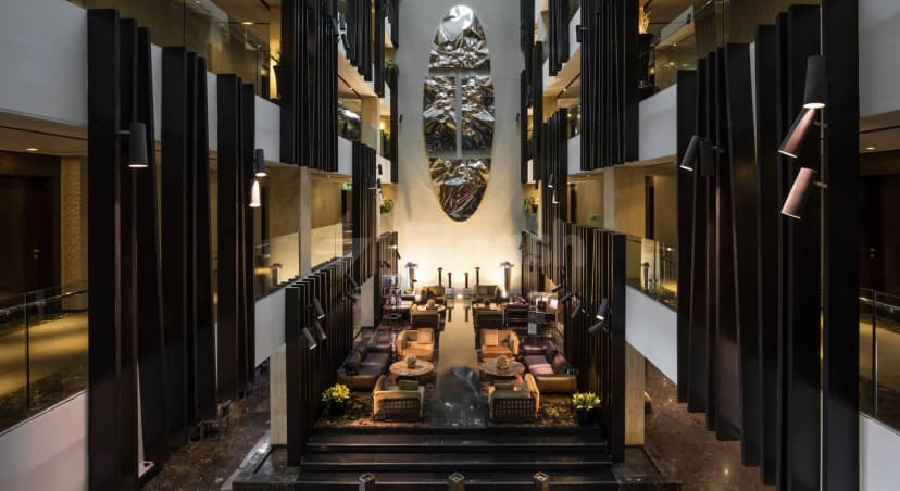 Entrance hall of Signature by Sanjeev Kapoor Restaurant Dubai featuring black vertical slats and a large metallic wall