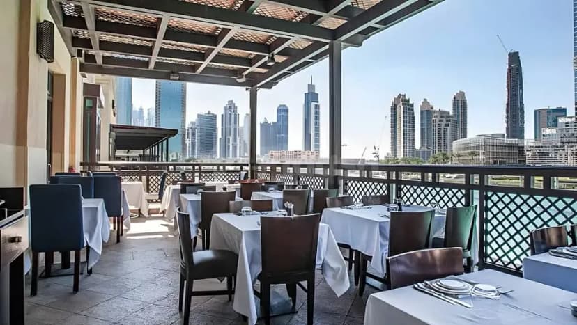 Rooftop terrace at Bice Mare Restaurant Dubai with set tables under a metal pergola, overlooking the city skyline