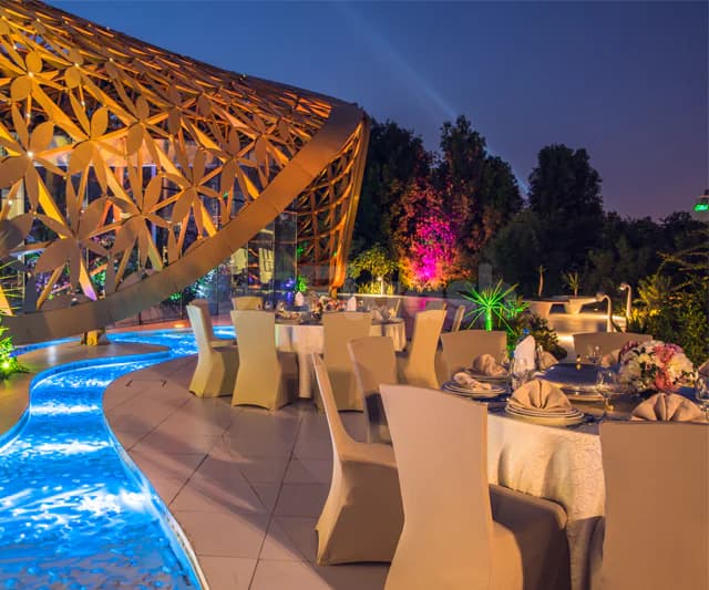 Rooftop terrace at Al Jawaher Reception and Convention Centre in Sharjah featuring an illuminated water feature and curved