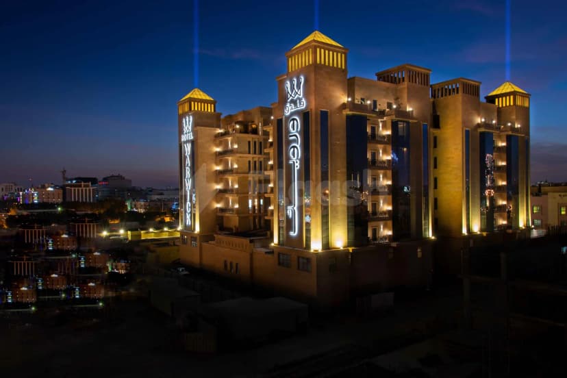 Hotel facade at Warwick Al Khobar in Al Khobar with illuminated vertical signage and pyramid-topped towers
