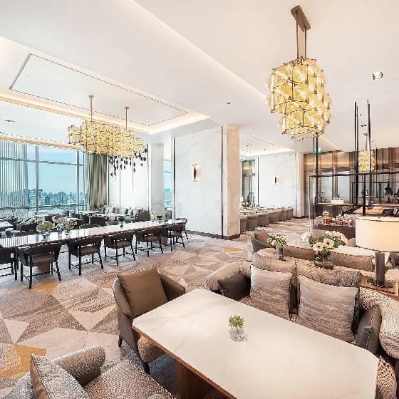 Restaurant interior at Momento Lounge Doha featuring a long dining table, black chairs, large windows with city view