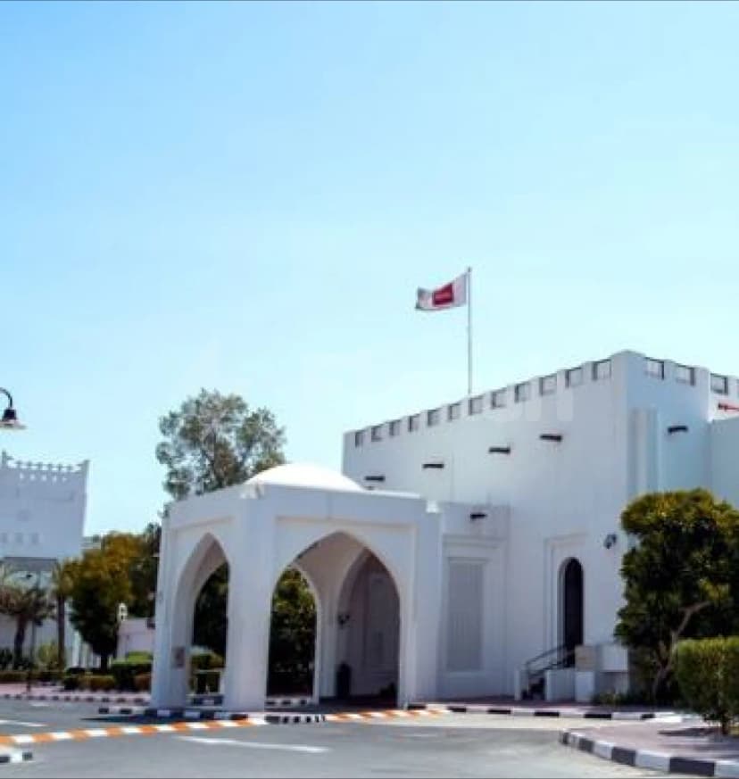 Al Jewan Hall Doha facade featuring a white arched entrance with dome and crenellated roofline under a clear