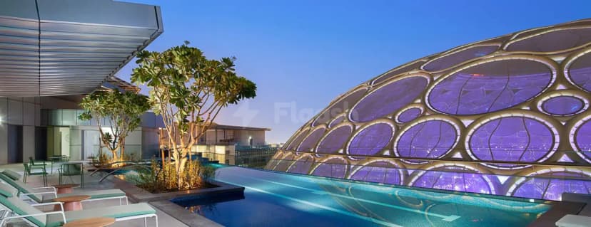Rooftop terrace at Rove Expo 2020 Dubai featuring an infinity pool and a large illuminated dome structure