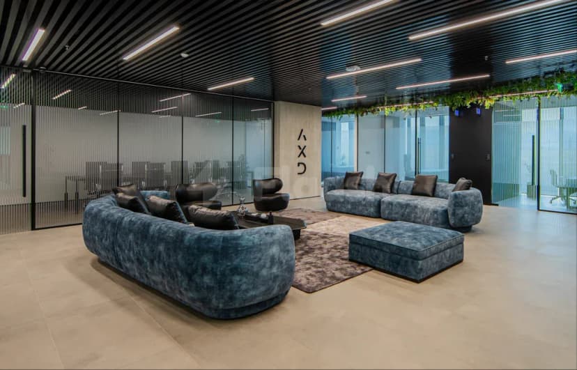 Entrance hall of AXD Space Membership Club in Dubai featuring blue velvet sofas, black leather armchairs