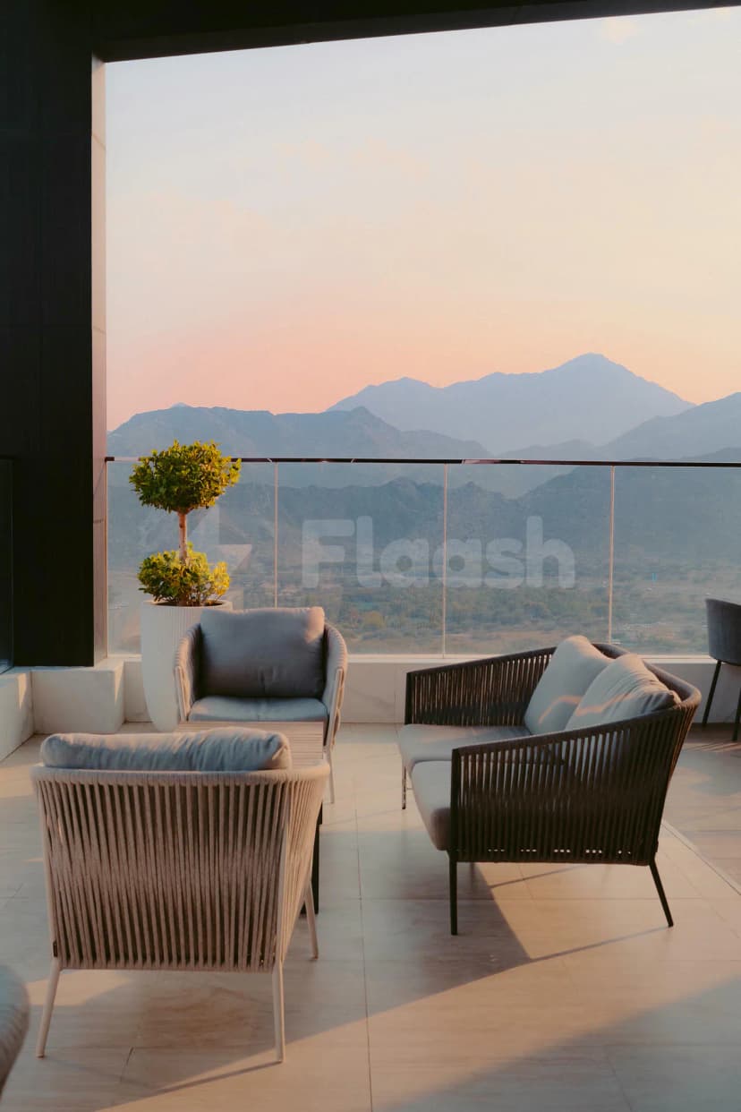 Rooftop terrace at Royal M Hotel & Resort Al Aqah Beach Fujairah featuring modern wicker seating, glass railing