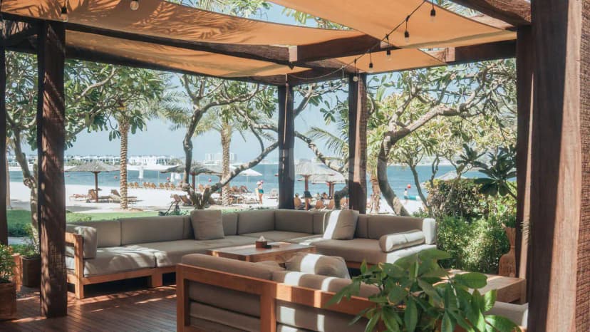Shaded terrace at Peaches & Cream Beach Restaurant Dubai with wooden pergola and beach view