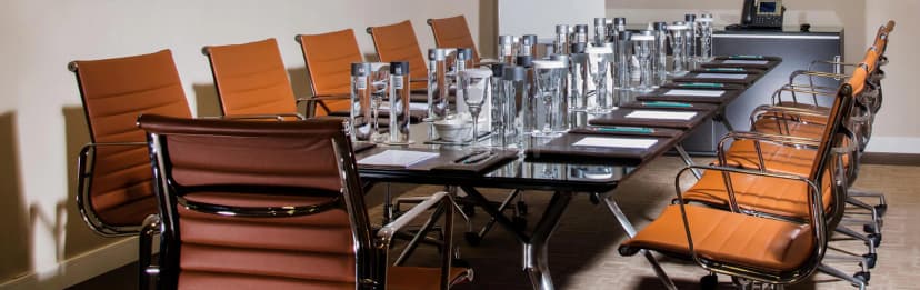 Boardroom at Al Jawaher Reception and Convention Centre in Sharjah featuring a black glass table with chrome legs