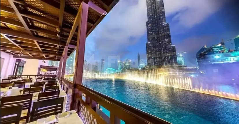 Bice Mare Restaurant Dubai dining area with wooden ceiling beams and glass railing overlooking illuminated fountains
