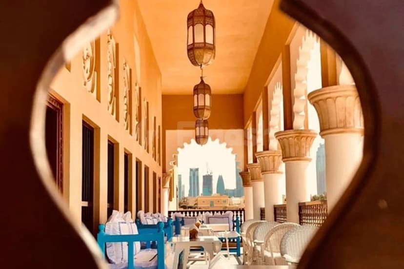 Rooftop terrace at Arabian Tea House Restaurant & Cafe Sharjah featuring hanging ornate lanterns and arched stone columns