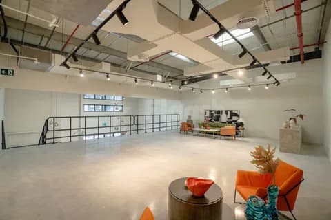 Meeting room at Slate The Space Dubai featuring an industrial ceiling with exposed ductwork and track lighting