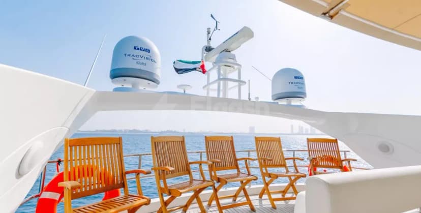 Sunseeker 82 Why Not Yacht Dubai rooftop terrace with wooden chairs, satellite domes, and UAE flag overlooking