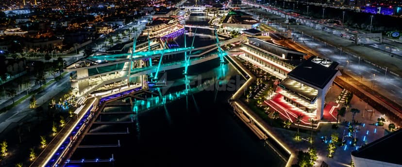 Rooftop terrace at Al Qana in Abu Dhabi featuring an illuminated turquoise bridge over a canal
