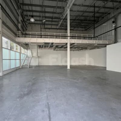 Open industrial meeting room at Alserkal Avenue in Dubai with mezzanine level and metal staircase