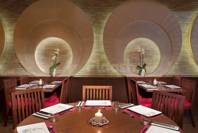 Restaurant at City Seasons Al Hamra Hotel Abu Dhabi featuring circular wall niches with orchids and a round