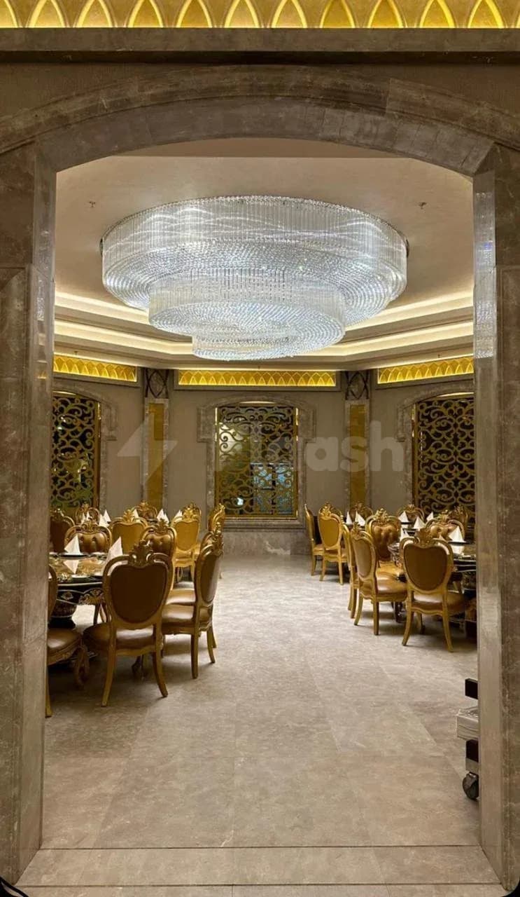 Restaurant at H Laylati Event Venue in Madinah featuring an arched stone doorway and a large crystal chandelier