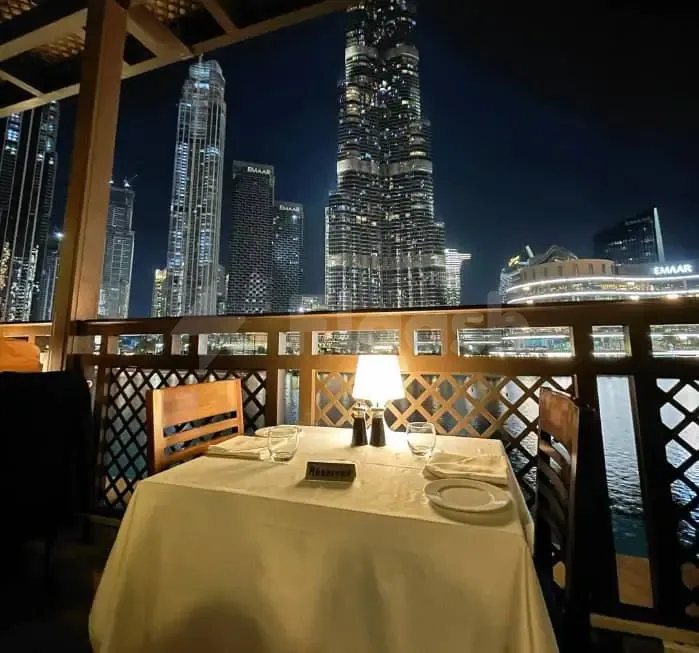 Rooftop terrace at Bice Mare Restaurant Dubai with a set dining table and lattice screen overlooking illuminated skyscrapers